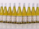 six bouteilles de vin blanc alignées sur une table