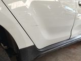 a close up of a white car with a denting on it