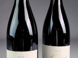 two bottles of wine sitting next to each other on a table