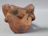 a small piece of pottery that has a face on it