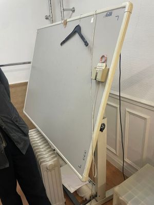 un homme qui se tient debout à côté d'un tableau blanc