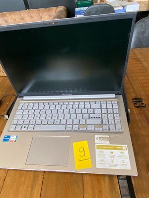 a laptop that is sitting on a table with a yellow sticker on it