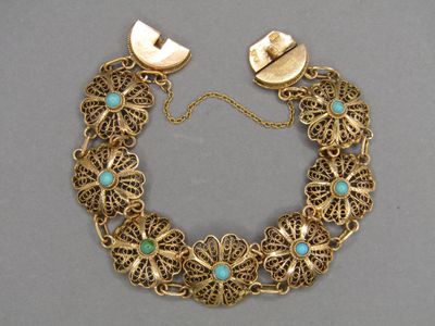 un gros plan d'un bracelet en or orné de pierres de turquoise