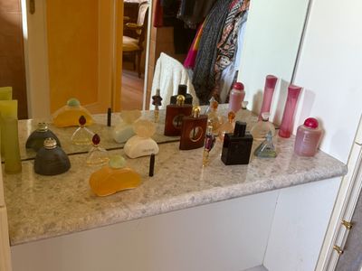 a bathroom counter with a lot of bottles of perfume on it