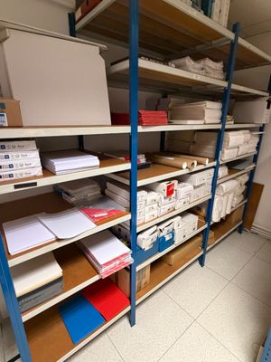 une pièce où il y a beaucoup de cartons et de papiers sur les étagères