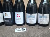 six bottles of wine are lined up on a table with a price tag