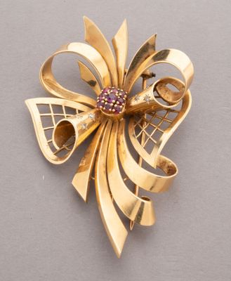 an image of a gold brooch with a pink stone center