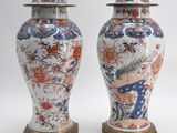 deux vases munis d'un couvercle sont posés côte à côte sur une surface blanche