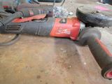a drill that is laying on the floor next to other tools