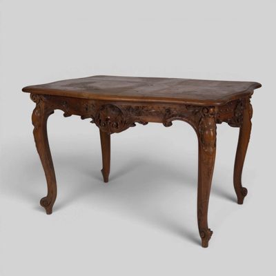 an old wooden table with carved legs and a wooden top