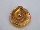 a gold object on a white surface with a white background
