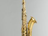a close up of a gold saxophone on a white background