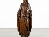 a wooden statue of a man with a robe on his head