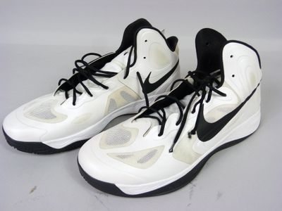 une paire de baskets blanches et noires avec des lacets noirs sur une tige blanche