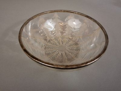 a clear glass bowl with a gold rim on a table