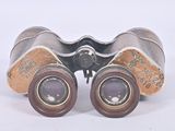 an old pair of binoculars sitting on top of a white surface