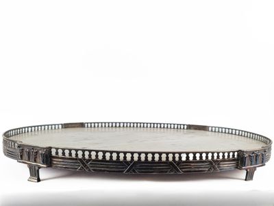 an oval metal tray with a decorative design on the top