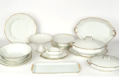 un service de table blanc et doré comprenant des assiettes, des bols et des plateaux