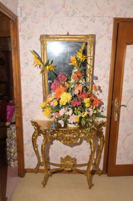 un vase de fleurs posé sur une table devant un miroir