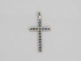 un pendentif en forme de croix orné de cristaux bleus sur fond blanc