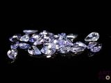 un tas de diamants violets et blancs sur une surface noire