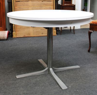 une table blanche avec un piètement en métal dans une pièce