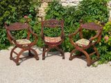 three chairs sitting next to each other in a garden