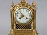 a gold and white clock sitting on top of a table