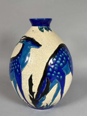 un vase bleu et blanc orné d'un motif représentant un cerf