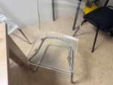 a clear chair that is sitting in the middle of a room