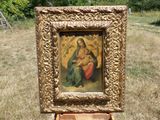 tableau représentant la Vierge à l'Enfant dans un cadre doré, au milieu d'un champ