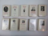 several books are lined up on a white surface