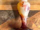 a vase sitting on a wooden table next to a pair of scissors