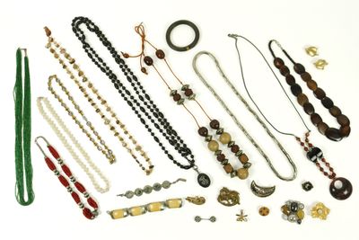divers colliers et bracelets disposés sur une surface blanche