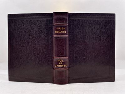 un vieux livre à la couverture en cuir posé sur une table blanche