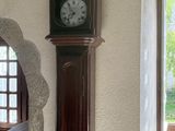a grandfather clock on the wall next to a window