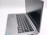 a silver laptop computer sitting on top of a white table