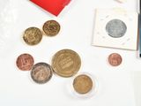 a lot of coins that are on the table next to a laptop