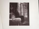 black and white photograph of a man sitting on a couch in front of a window