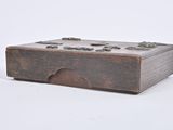 a small wooden box with metal buttons on it