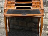 a small wooden desk with a black leather top