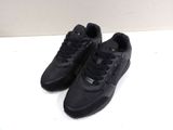 a pair of black sneakers sitting on top of a white table