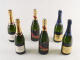 several bottles of champagne are lined up on a white surface