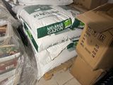 many bags of food sitting on top of a pile of boxes