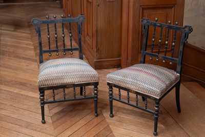 deux chaises assises l'une à côté de l'autre sur un sol en bois dur