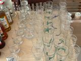 many glasses and bottles on a table with bottles on it
