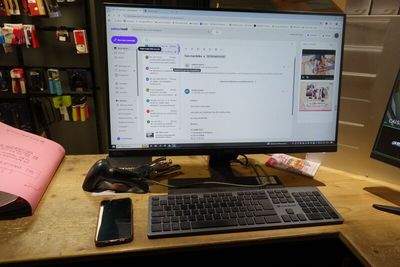 un écran d'ordinateur posé sur un bureau, à côté d'un clavier