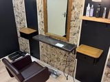 a room with a chair, mirror, and a hair dryer