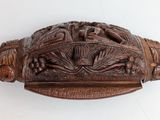 a close up of a carved object on a white surface