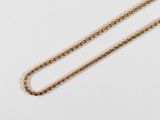 a close up of a gold chain on a white surface